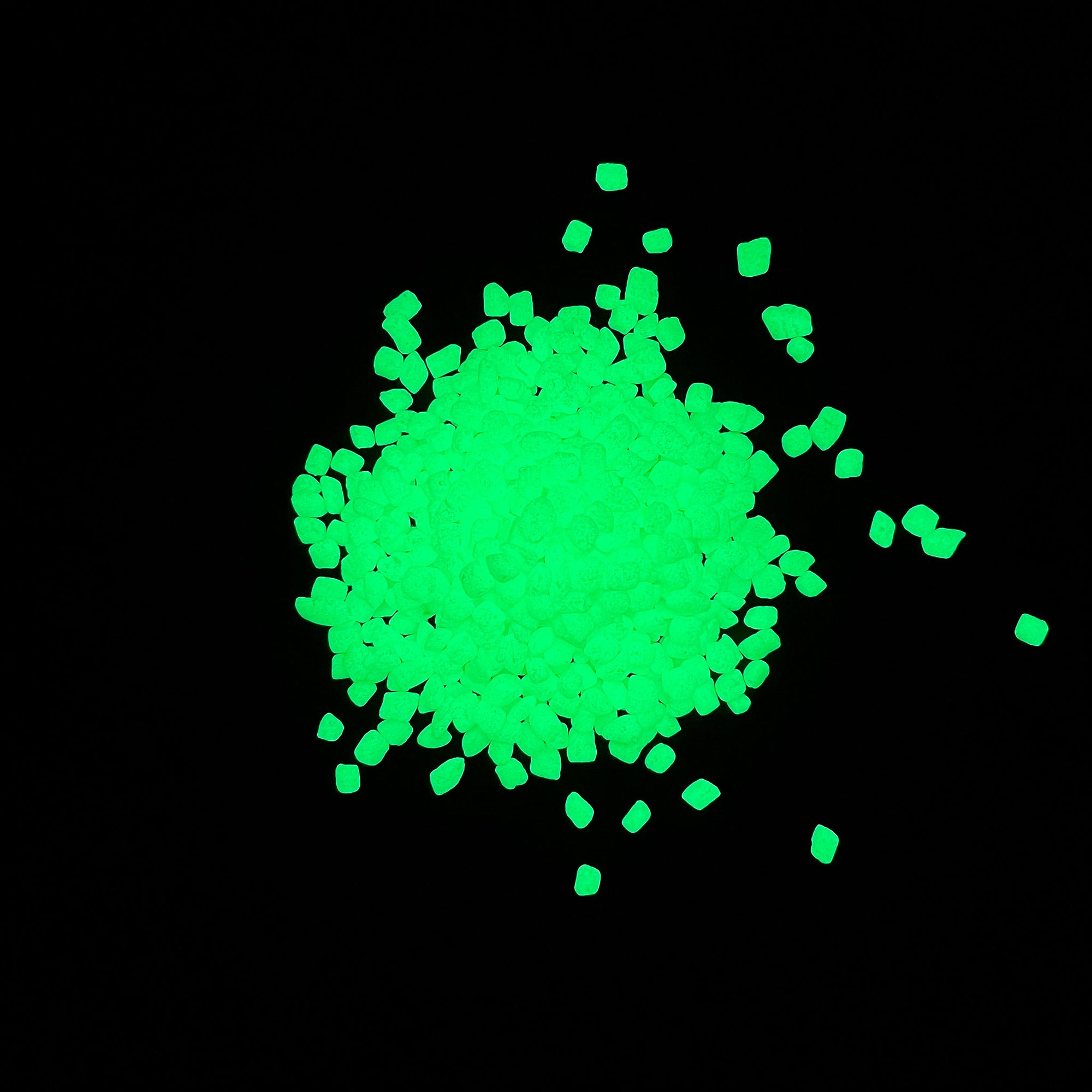 Night time glowing view of a pile of Emerald Yellow Glowing Mini Pebbles