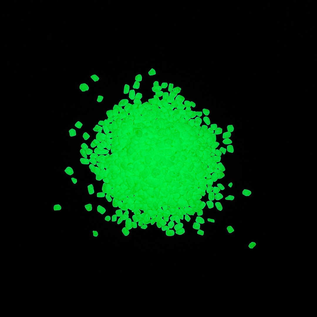 Night time glowing view of a pile of Emerald Yellow Glowing Mini Pebbles