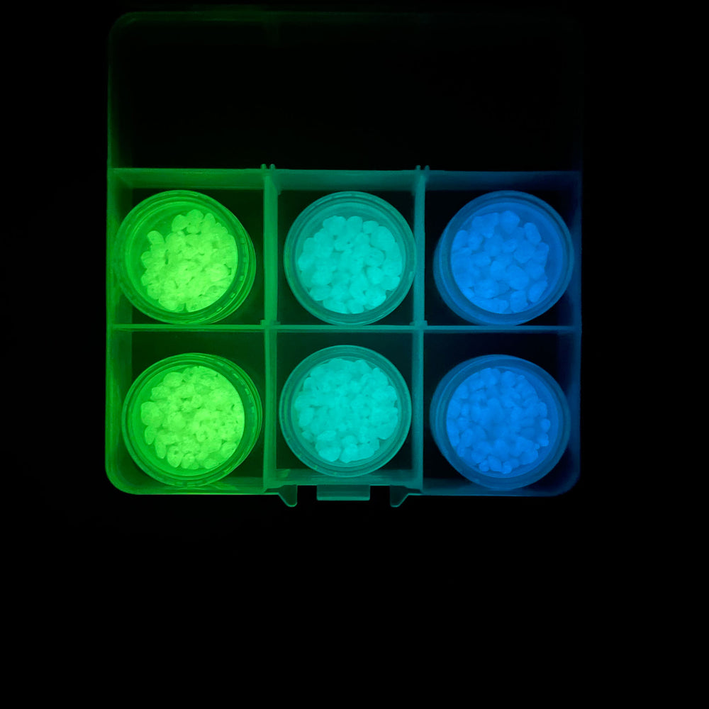This Premium Glowing Mini Pebble Sample Kit contains AGT™ Glowing Mini Pebble samples in all three colors; Emerald Yellow, Aqua Blue and Sky Blue and in both 1/4" & 1/8" sizes. Glow in the dark view.
