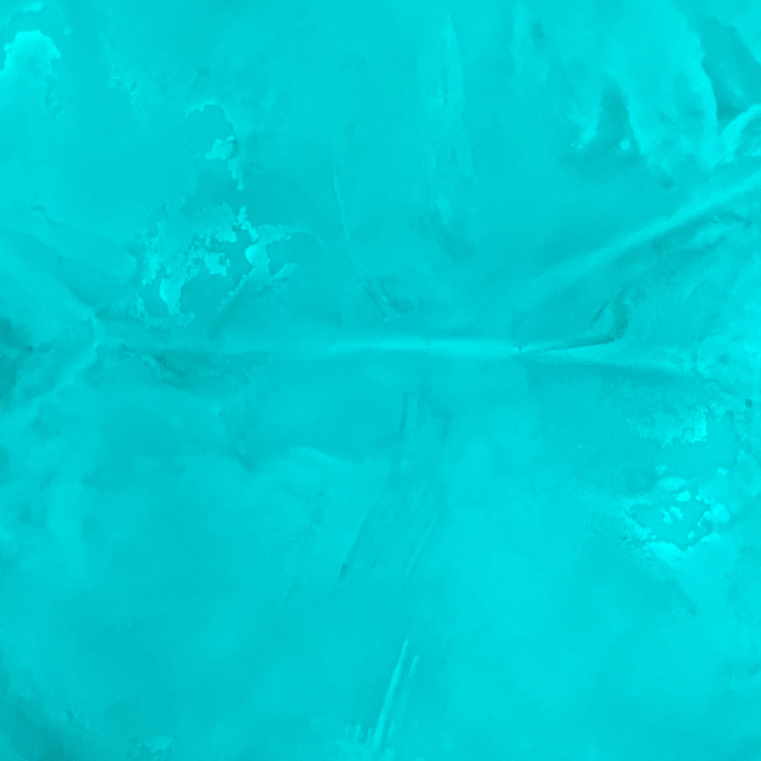 Close up view of a glowing 1lb. bag of Aqua Blue Fine Glow Sand