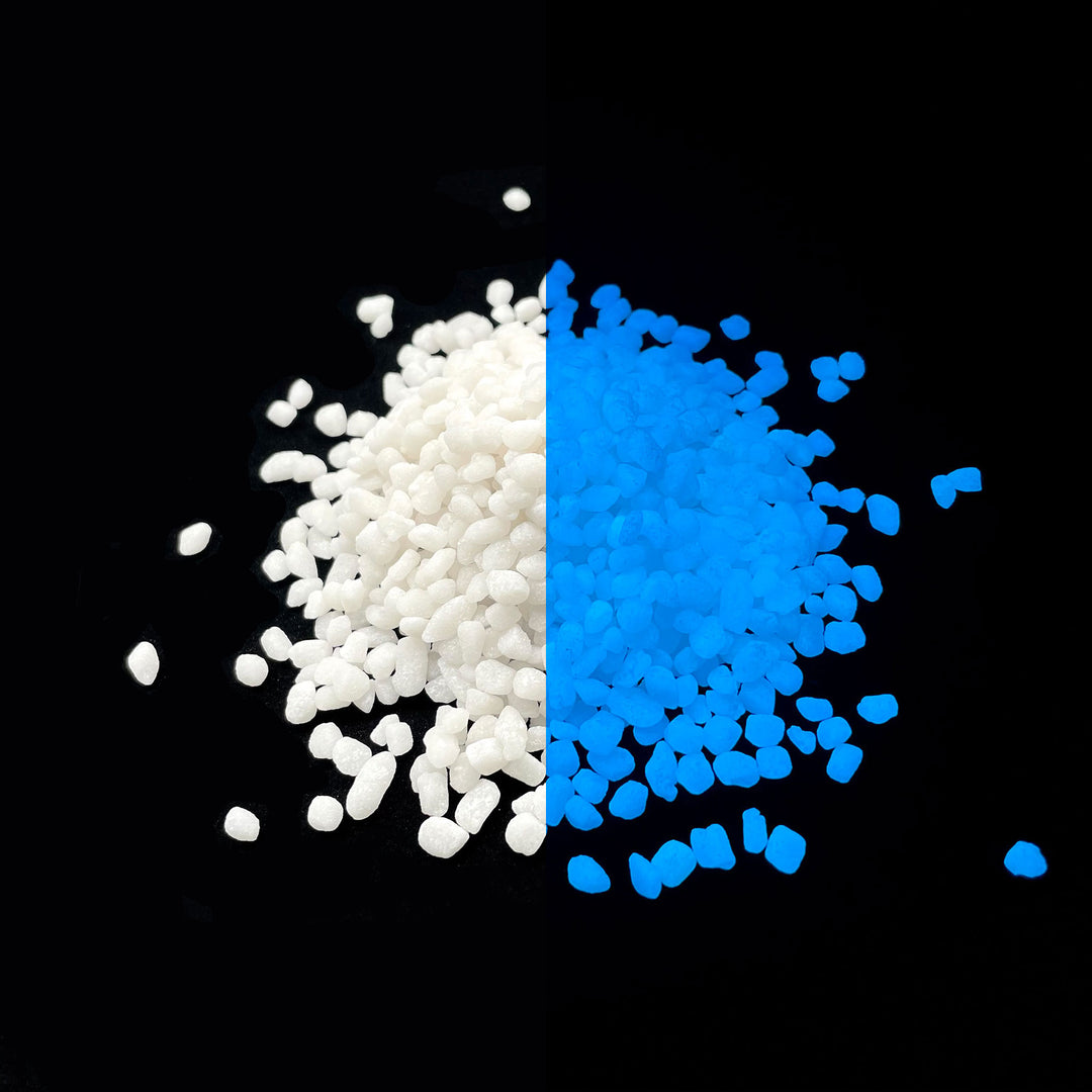 Side by side glow in the dark comparison of AGT™ Sky Blue Mini Pebbles. Larger pile.